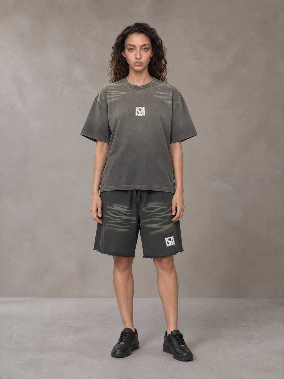 Model wearing the SM Vintage Washed T-shirt and SM Vintage Washed Shorts in Deep Charcoal, front view.