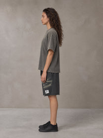 Model wearing the SM Vintage Washed T-shirt and SM Vintage Washed Shorts in Deep Charcoal, side profile.