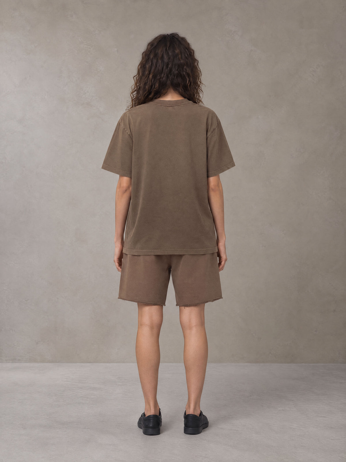 Model wearing the SM Vintage Washed T-shirt and SM Vintage Washed Shorts in Deep Coffee, rear view.
