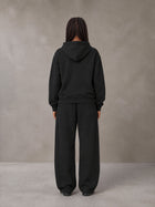 Model wearing the SM Sig. Plaid Zip Hoodie and SM Sig. Plaid Sweatpants in Midnight Black, rear view.