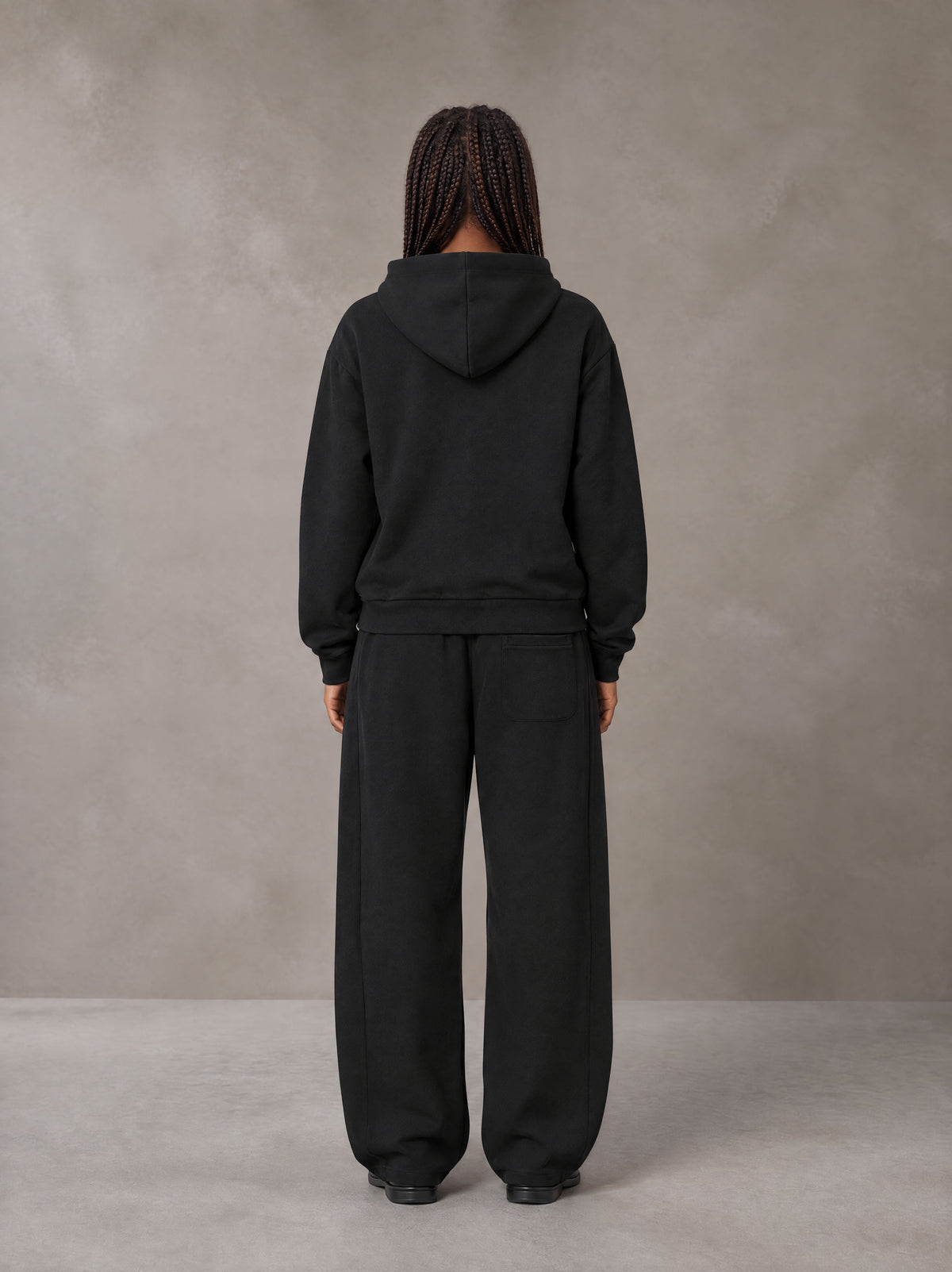Model wearing the SM Sig. Plaid Zip Hoodie and SM Sig. Plaid Sweatpants in Midnight Black, rear view.