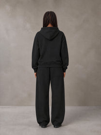 Model wearing the SM Sig. Plaid Zip Hoodie and SM Sig. Plaid Sweatpants in Midnight Black, rear view.