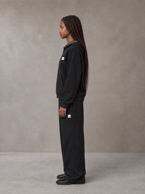Model wearing the SM Sig. Plaid Zip Hoodie and SM Sig. Plaid Sweatpants in Midnight Black, side profile.
