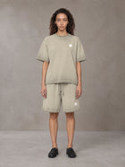 Model wearing the SM Sig. Reverse Dyed T-shirt and SM Sig. Reverse Dyed Shorts in Fine Sand, front view.