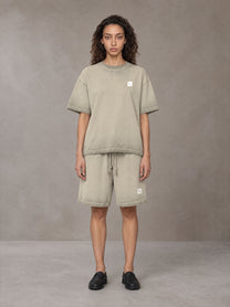 Model wearing the SM Sig. Reverse Dyed T-shirt and SM Sig. Reverse Dyed Shorts in Fine Sand, front view.