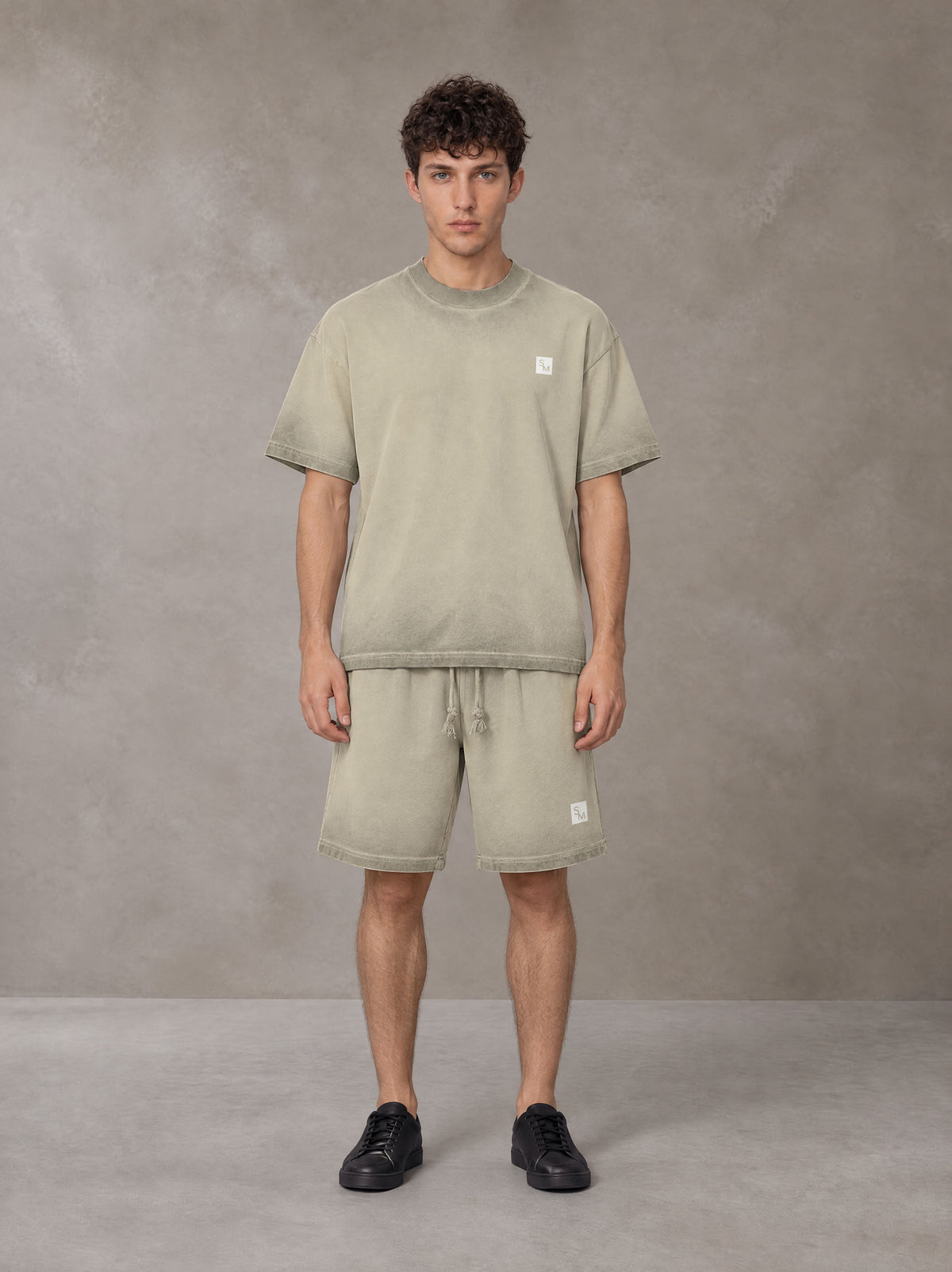Model wearing the SM Sig. Reverse Dyed T-shirt and SM Sig. Reverse Dyed Shorts in Fine Sand, front view.