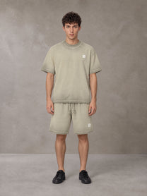 Model wearing the SM Sig. Reverse Dyed T-shirt and SM Sig. Reverse Dyed Shorts in Fine Sand, front view.