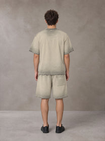 Model wearing the SM Sig. Reverse Dyed T-shirt and SM Sig. Reverse Dyed Shorts in Fine Sand, rear view.