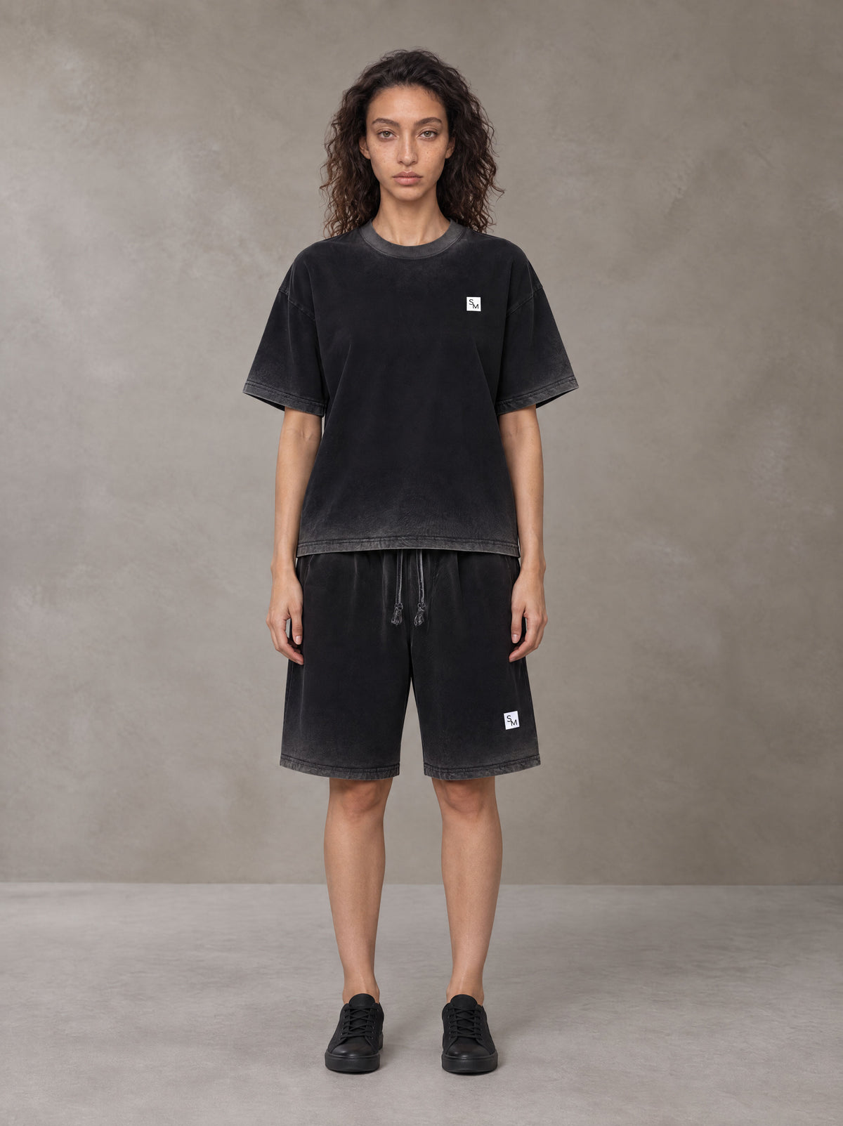 Model wearing the SM Sig. Reverse Dyed T-shirt and SM Sig. Reverse Dyed Shorts in Midnight Black, front view.