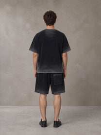 Model wearing the SM Sig. Reverse Dyed T-shirt and SM Sig. Reverse Dyed Shorts in Midnight Black, rear view.