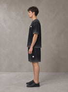 Model wearing the SM Sig. Reverse Dyed T-shirt and SM Sig. Reverse Dyed Shorts in Midnight Black, side profile.