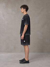 Model wearing the SM Sig. Reverse Dyed T-shirt and SM Sig. Reverse Dyed Shorts in Midnight Black, side profile.