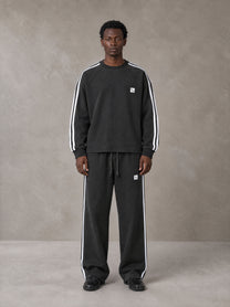 Model wearing the SM Sig. Snow Line Sweatshirt and SM Sig. Snow Line Sweatpants in Midnight Black, front view.
