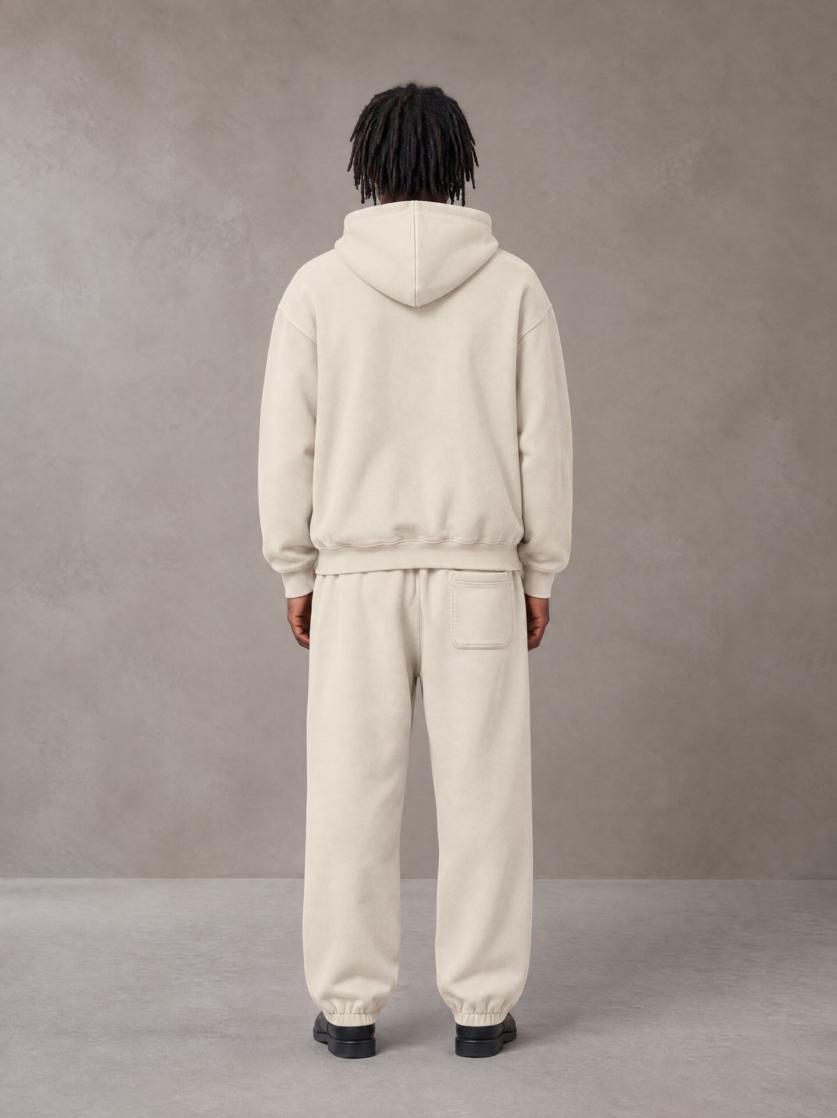 Model wearing the SM Sunfade Fleeced Hoodie and SM Sunfade Fleeced Sweatpants in Camel Tan, rear view.