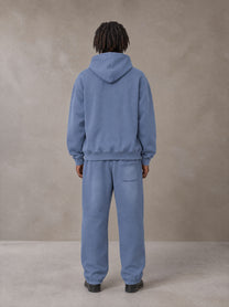 Model wearing the SM Sunfade Fleeced Hoodie and SM Sunfade Fleeced Sweatpants in Deep Denim, rear view.