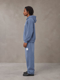 Model wearing the SM Sunfade Fleeced Hoodie and SM Sunfade Fleeced Sweatpants in Deep Denim, side profile.