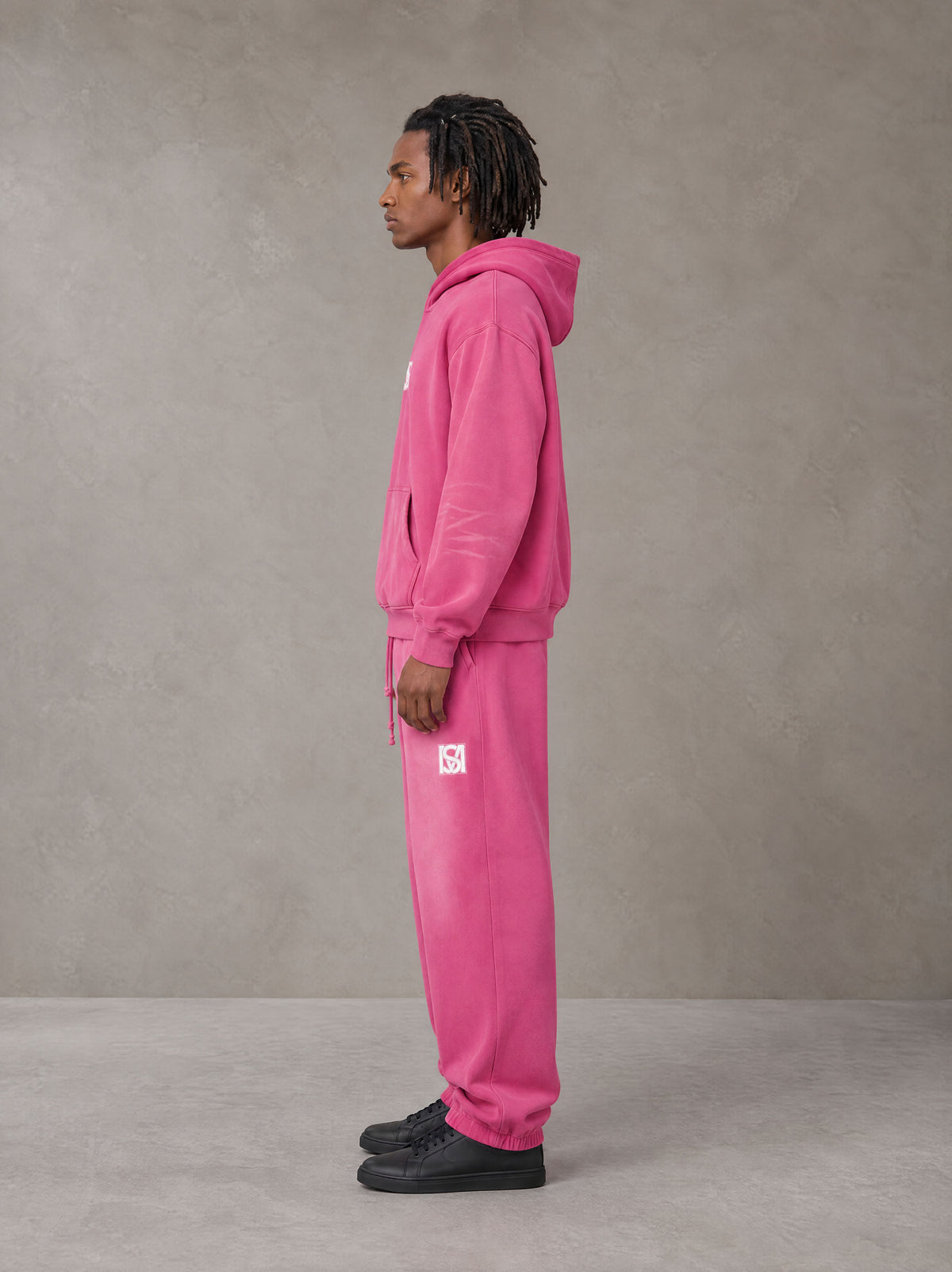 Model wearing the SM Sunfade Fleeced Hoodie and SM Sunfade Fleeced Sweatpants in Vivid Pink, side profile.