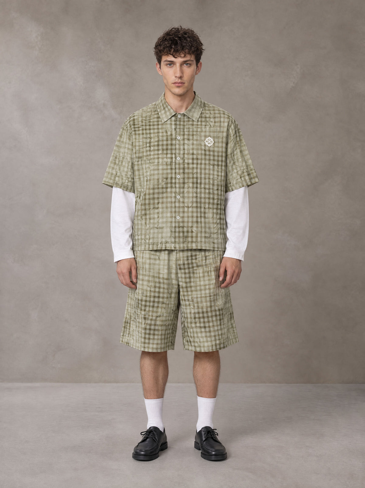 Model wearing the SM Eternal Fleur Mirage Shirt and SM Eternal Fleur Mirage Shorts in Moss, front view.
