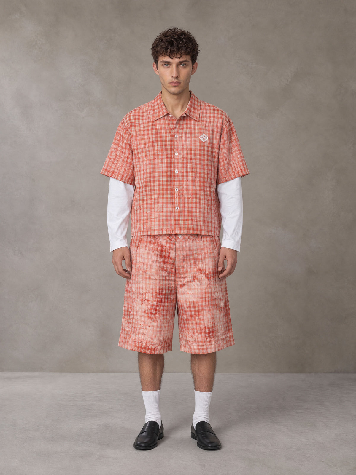 Model wearing the SM Eternal Fleur Mirage Shirt and SM Eternal Fleur Mirage Shorts in Persimmon, front view.