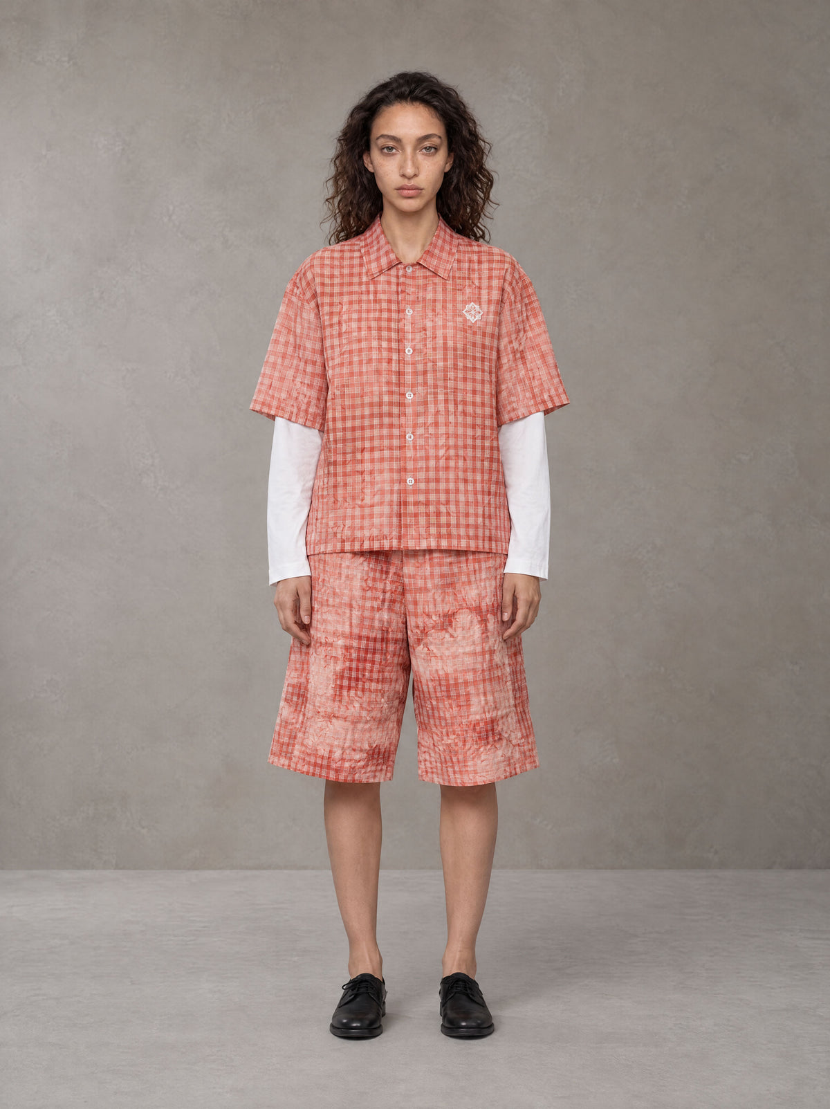Model wearing the SM Eternal Fleur Mirage Shirt and SM Eternal Fleur Mirage Shorts in Persimmon, front view.