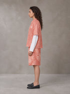 Model wearing the SM Eternal Fleur Mirage Shirt and SM Eternal Fleur Mirage Shorts in Persimmon, side profile.