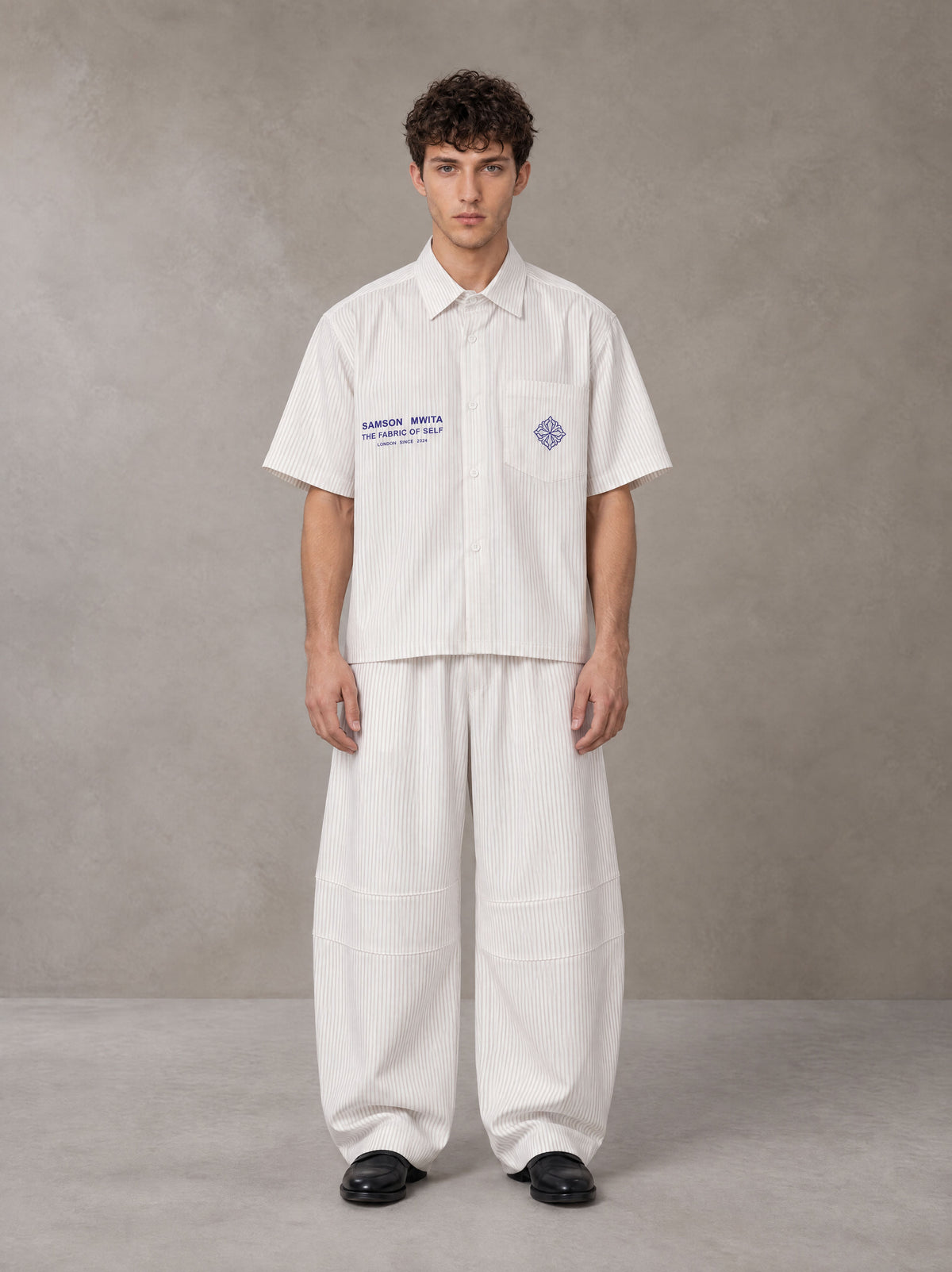 Model wearing the SM The Fabric Of Self Shirt and SM The Fabric Of Self Trousers in Ivory White, front view.