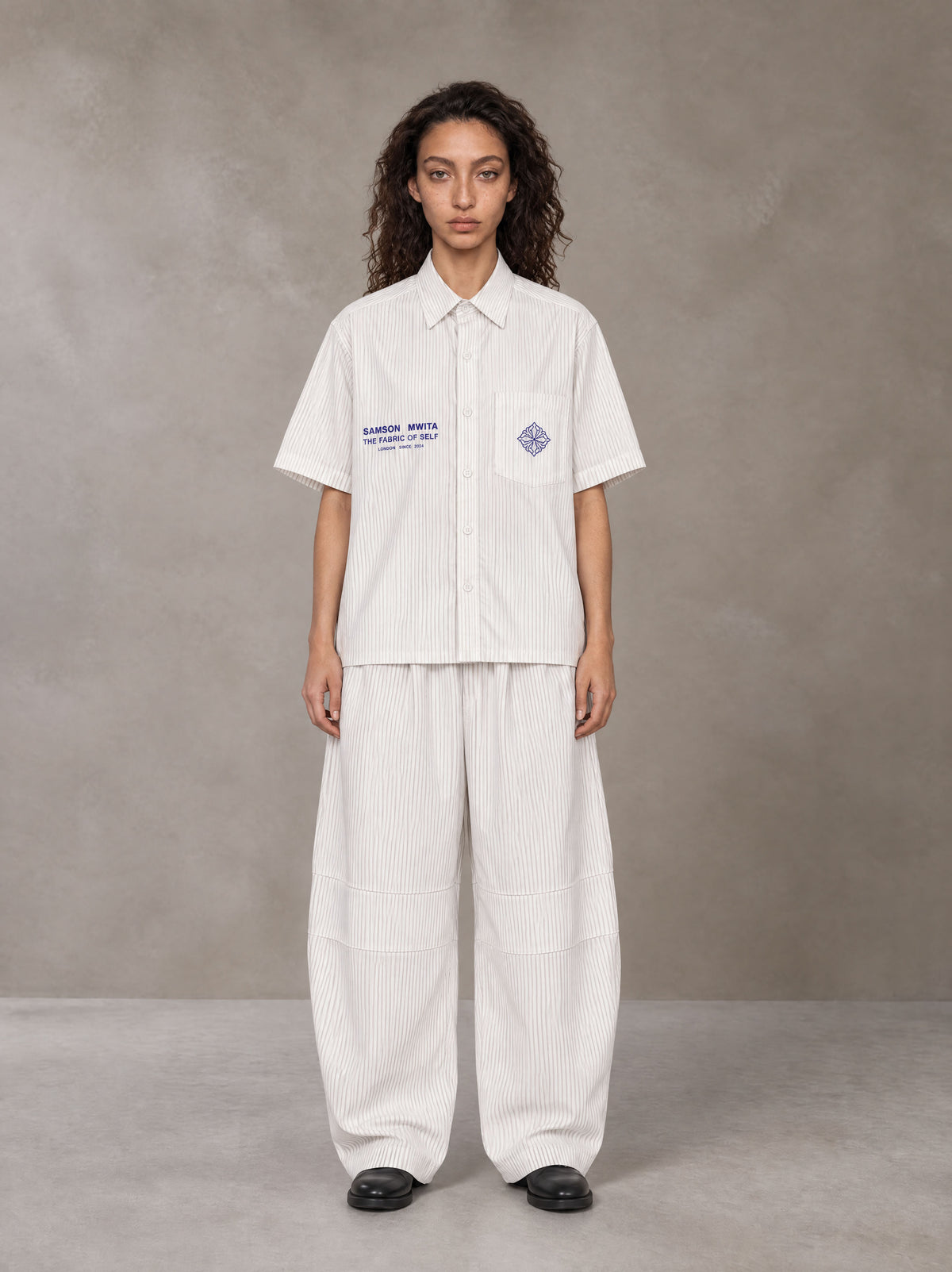 Model wearing the SM The Fabric Of Self Shirt and SM The Fabric Of Self Trousers in Ivory White, front view.