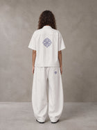 Model wearing the SM The Fabric Of Self Shirt and SM The Fabric Of Self Trousers in Ivory White, rear view.