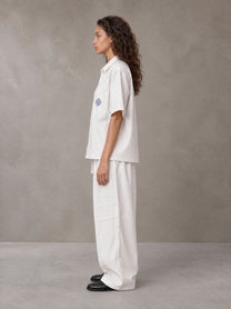 Model wearing the SM The Fabric Of Self Shirt and SM The Fabric Of Self Trousers in Ivory White, side profile.