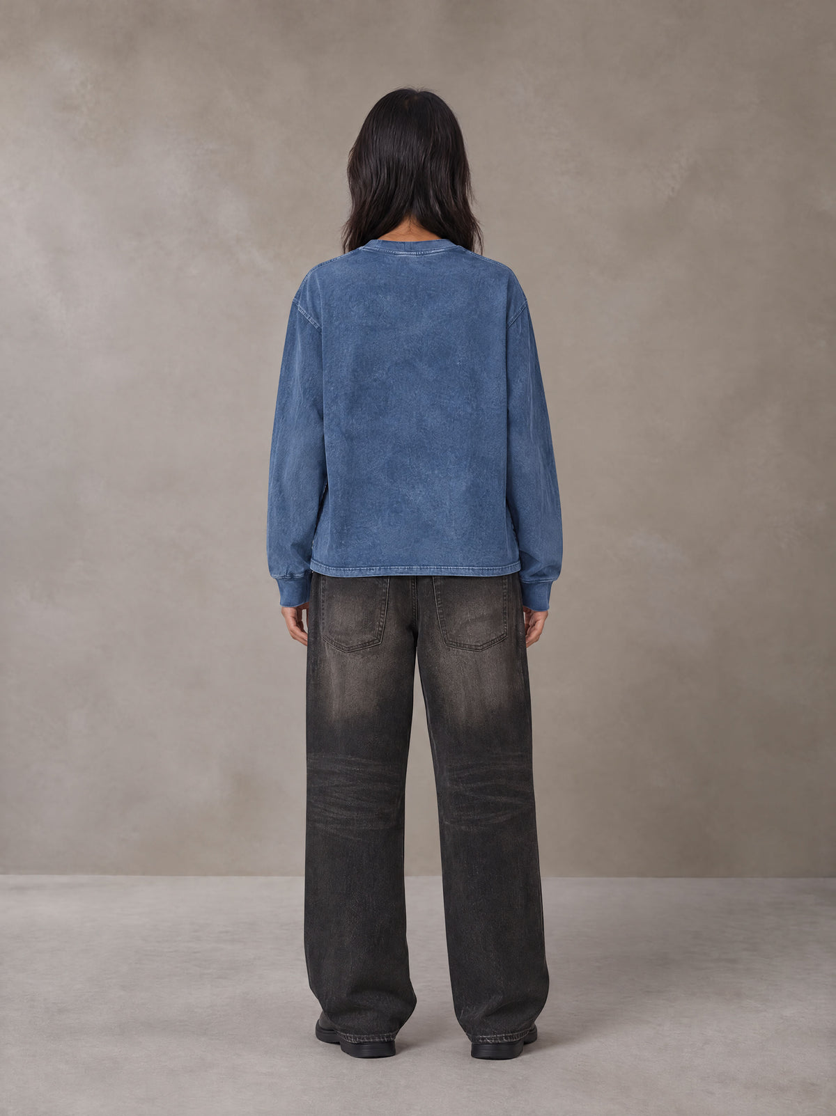 Model wearing the SM Acid Wash Long Sleeve T-shirt in Chambray, rear view.
