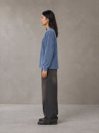 Model wearing the SM Acid Wash Long Sleeve T-shirt in Chambray, side profile.