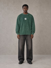 Model wearing the SM Acid Wash Long Sleeve T-shirt in Dark Green, front view.