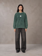 Model wearing the SM Acid Wash Long Sleeve T-shirt in Dark Green, front view.