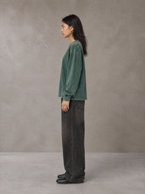 Model wearing the SM Acid Wash Long Sleeve T-shirt in Dark Green, side profile.