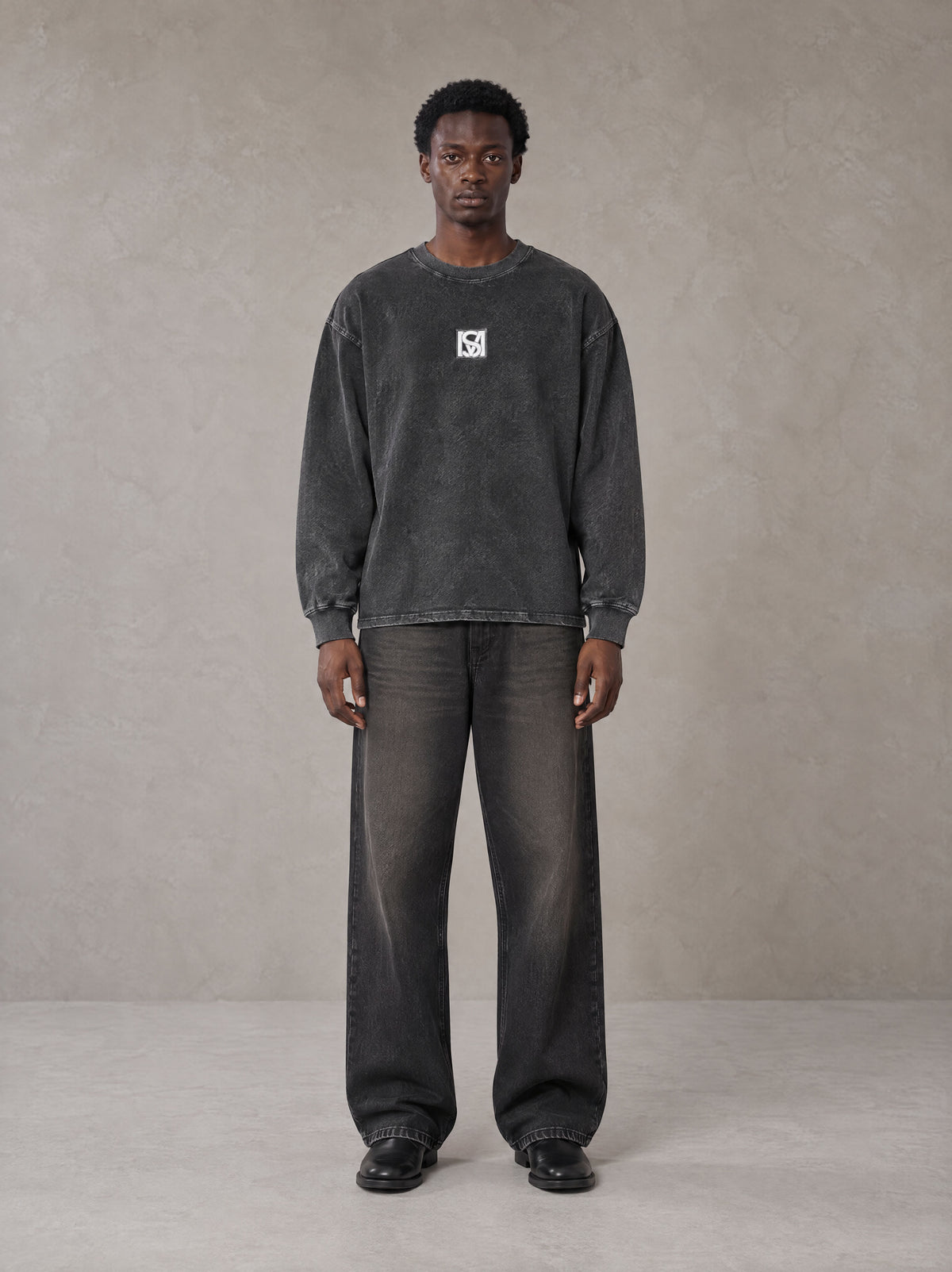 Model wearing the SM Acid Wash Long Sleeve T-shirt in Deep Charcoal, front view.