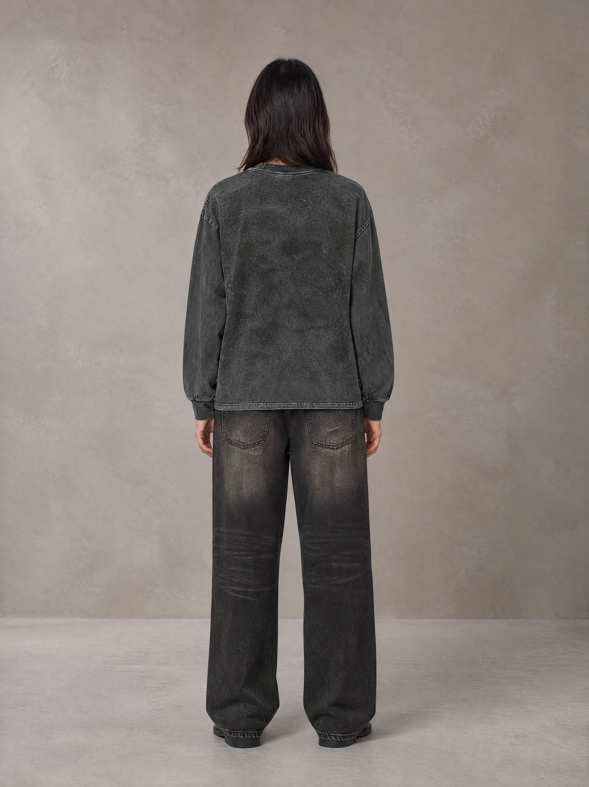 Model wearing the SM Acid Wash Long Sleeve T-shirt in Deep Charcoal, rear view.