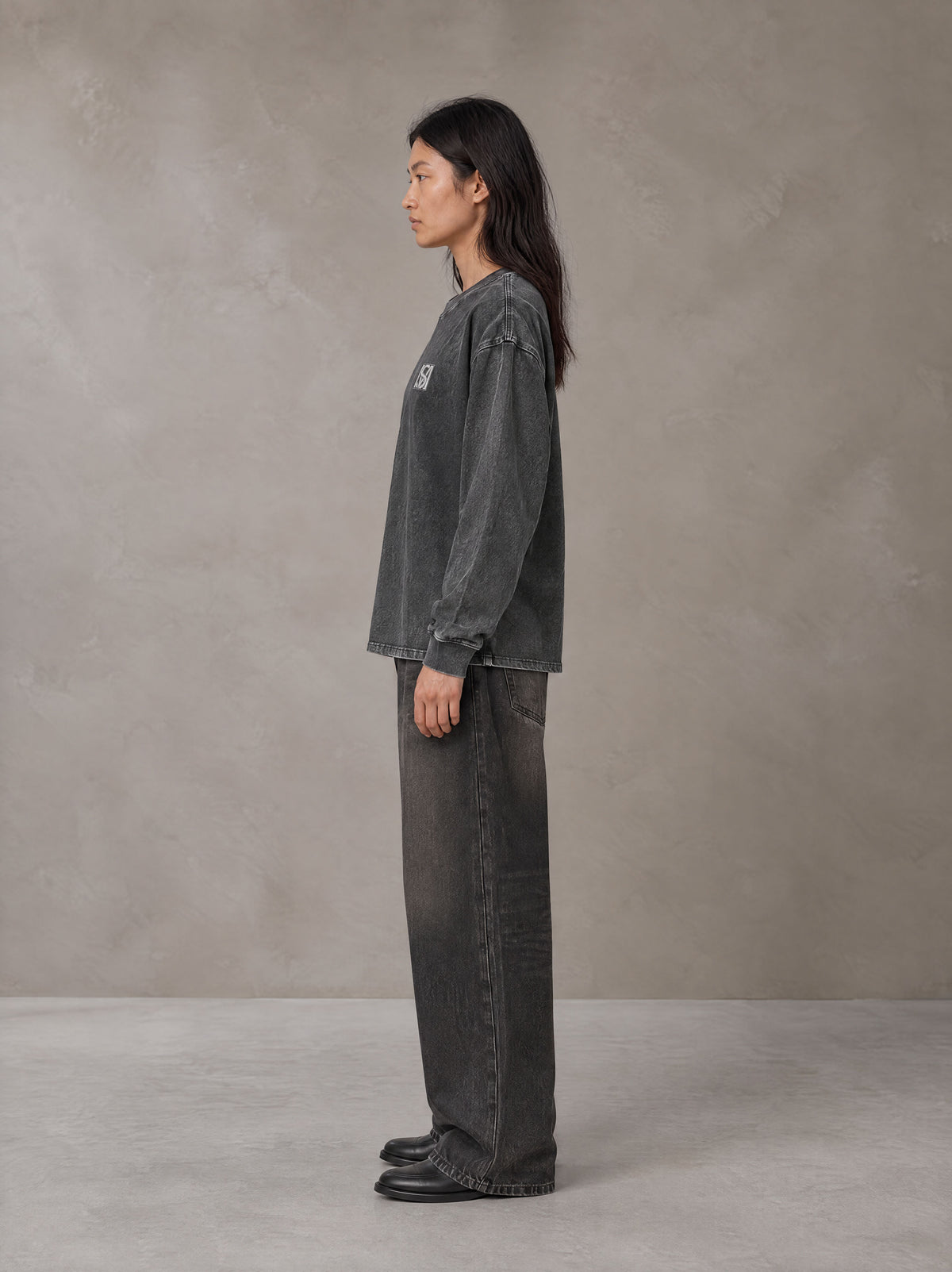Model wearing the SM Acid Wash Long Sleeve T-shirt in Deep Charcoal, side profile.