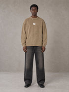 Model wearing the SM Acid Wash Long Sleeve T-shirt in Fine Sand, front view.