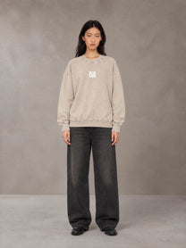 Model wearing the SM Acid Wash Sweatshirt in Apricot Tint, front view.