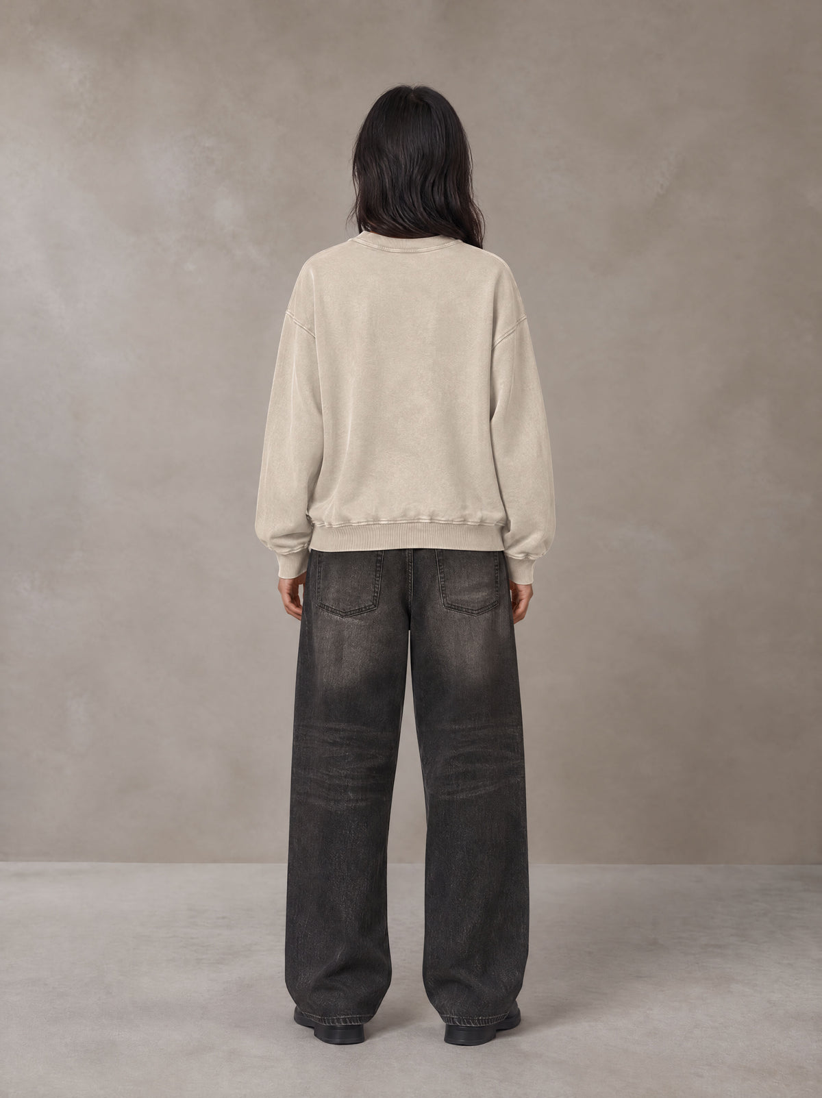 Model wearing the SM Acid Wash Sweatshirt in Apricot Tint, rear view.