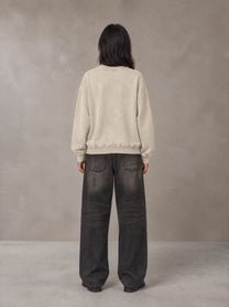 Model wearing the SM Acid Wash Sweatshirt in Apricot Tint, rear view.