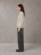 Model wearing the SM Acid Wash Sweatshirt in Apricot Tint, side profile.