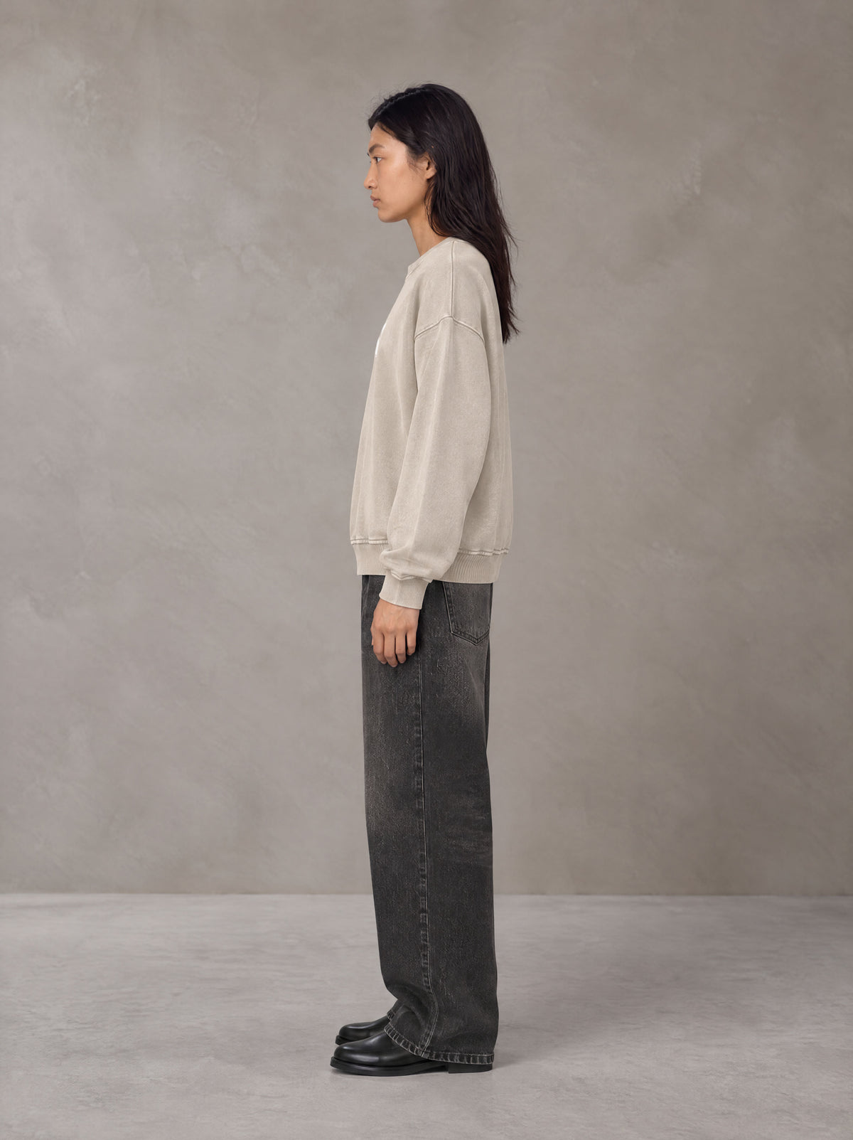 Model wearing the SM Acid Wash Sweatshirt in Apricot Tint, side profile.