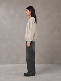 Model wearing the SM Acid Wash Sweatshirt in Apricot Tint, side profile.