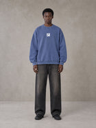 Model wearing the SM Acid Wash Sweatshirt in Classic Blue, front view.