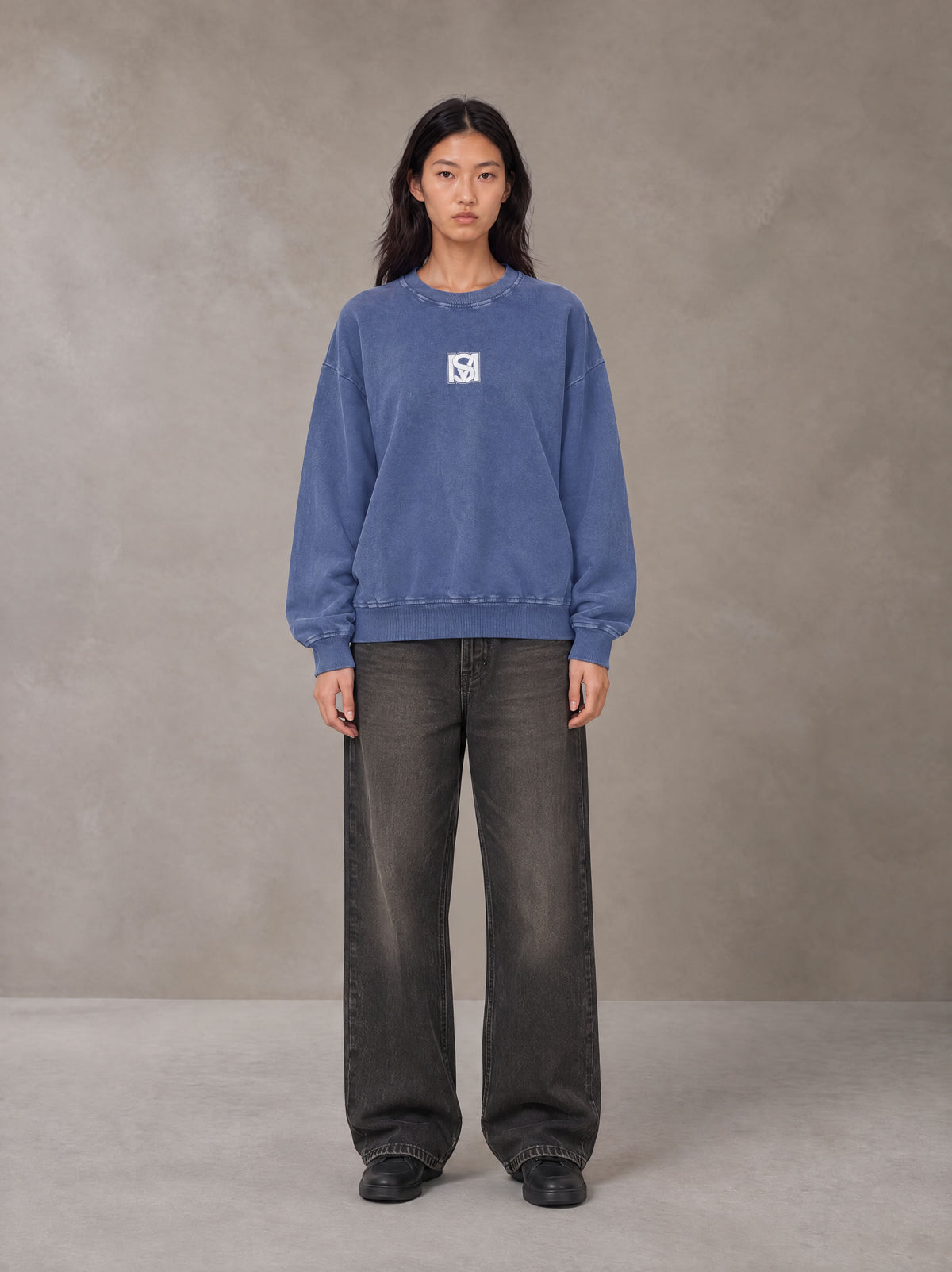 Model wearing the SM Acid Wash Sweatshirt in Classic Blue, front view.