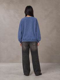 Model wearing the SM Acid Wash Sweatshirt in Classic Blue, rear view.