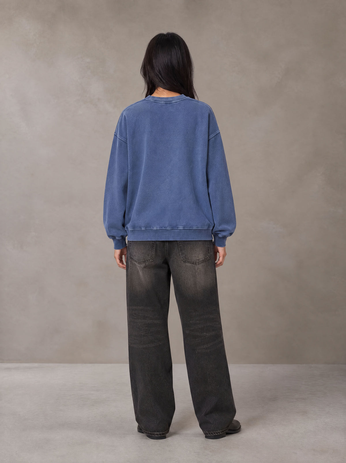 Model wearing the SM Acid Wash Sweatshirt in Classic Blue, rear view.