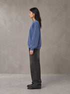 Model wearing the SM Acid Wash Sweatshirt in Classic Blue, side profile.