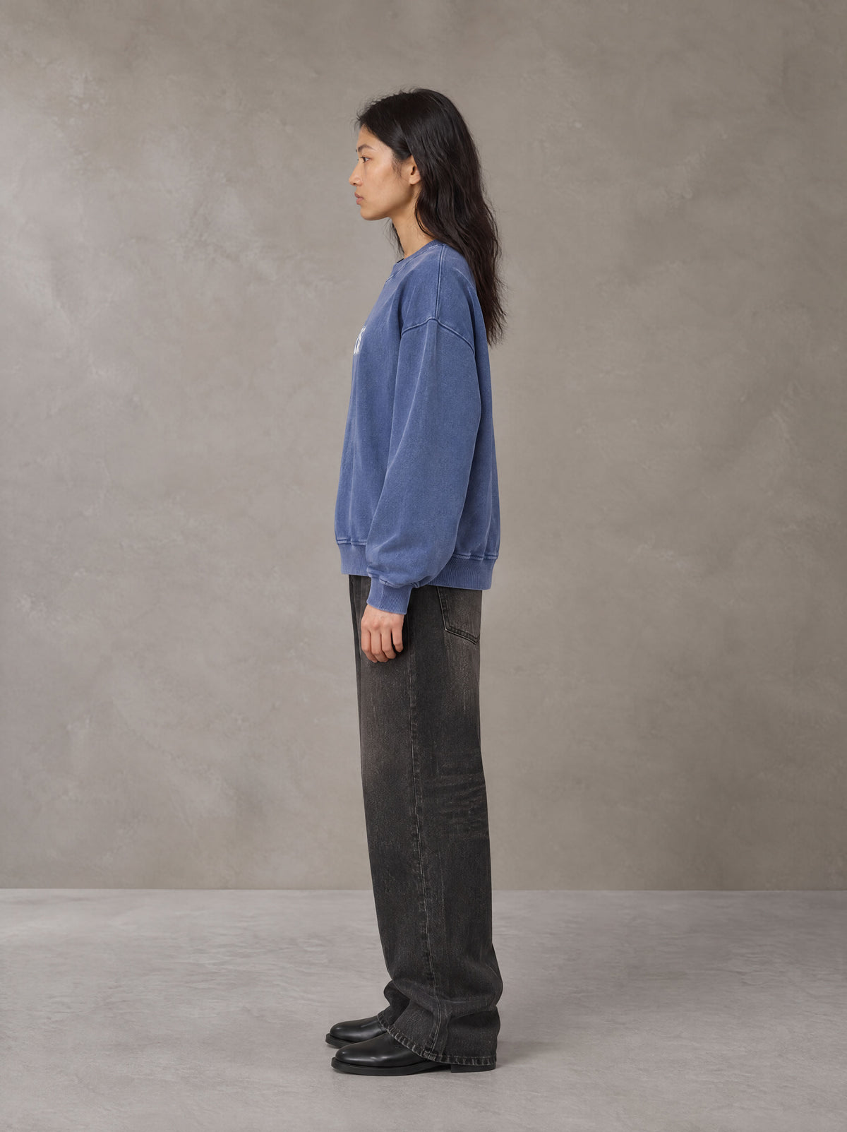 Model wearing the SM Acid Wash Sweatshirt in Classic Blue, side profile.